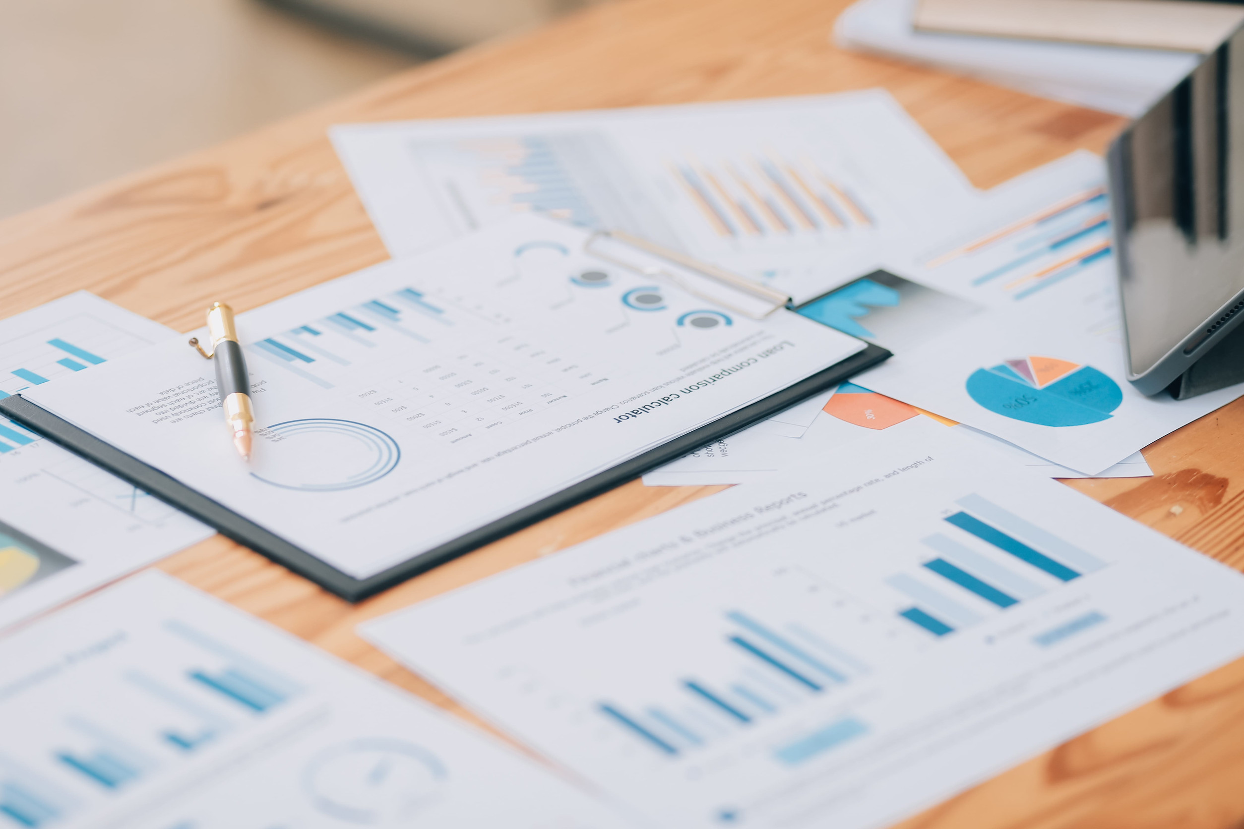 Technology planning documents with business performance charts, reports, and financial graphs on an office desk.