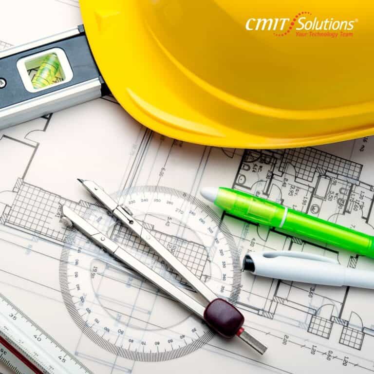 Blueprints, a yellow hard hat, and drafting tools showcasing IT concerns for construction companies in Austin, TX