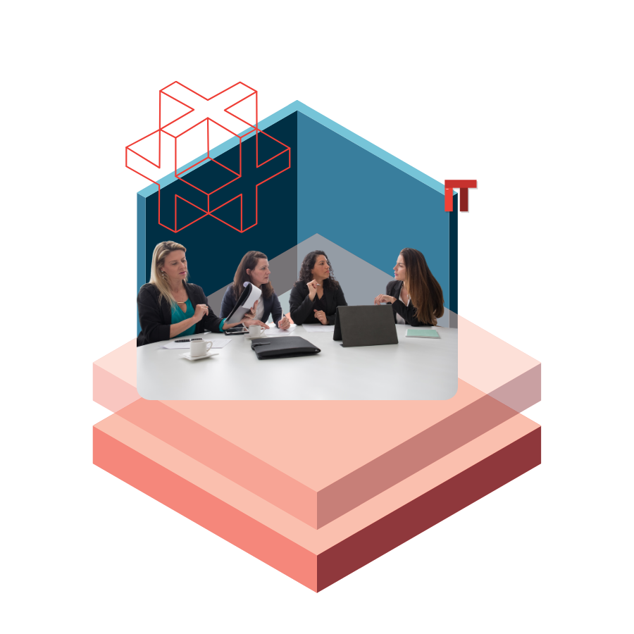 Four women in a business meeting around a table with laptops and documents, set against abstract blue shapes and red IT lettering in the background.