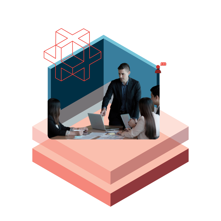 Business meeting: a man presents with a laptop to colleagues around a table, blue walls and a geometric logo in the background.