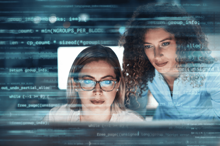 Digitally enhanced shot of two attractive businesswomen working in the office superimposed over multiple lines of computer code stock photo