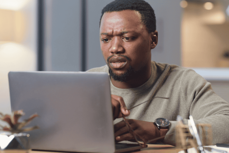 Confused, black man and reading email on laptop with hacker notification update and software fail. Entrepreneur person anxiety, fear and surprise with cyber security breach with information