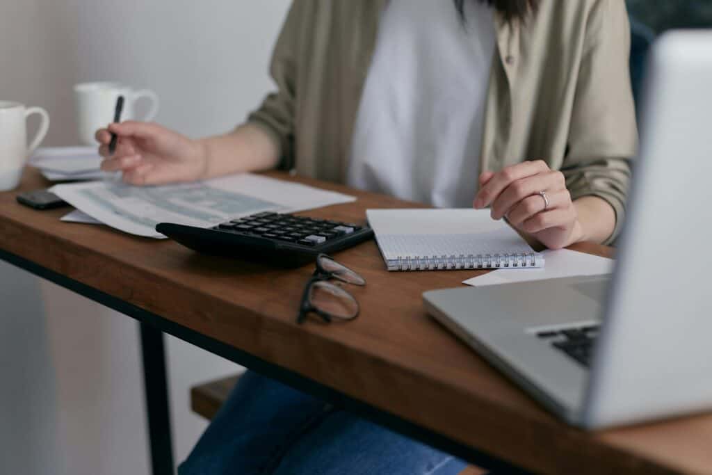 accountant working with desk full of papers, computer and calculator