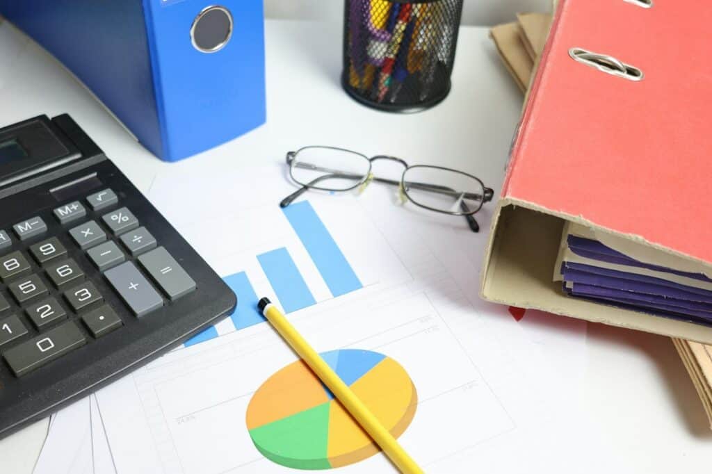 Accountant's desk with a calculator, charts and binders