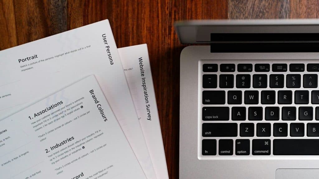 Printed policy documents next to a laptop