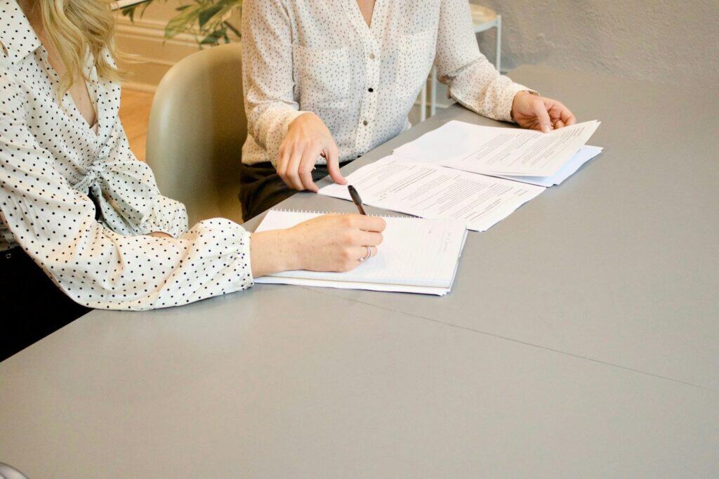 Professionals reviewing and signing documents in a client meeting
