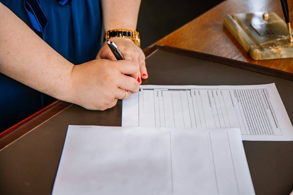 Person writing notes on compliance documents