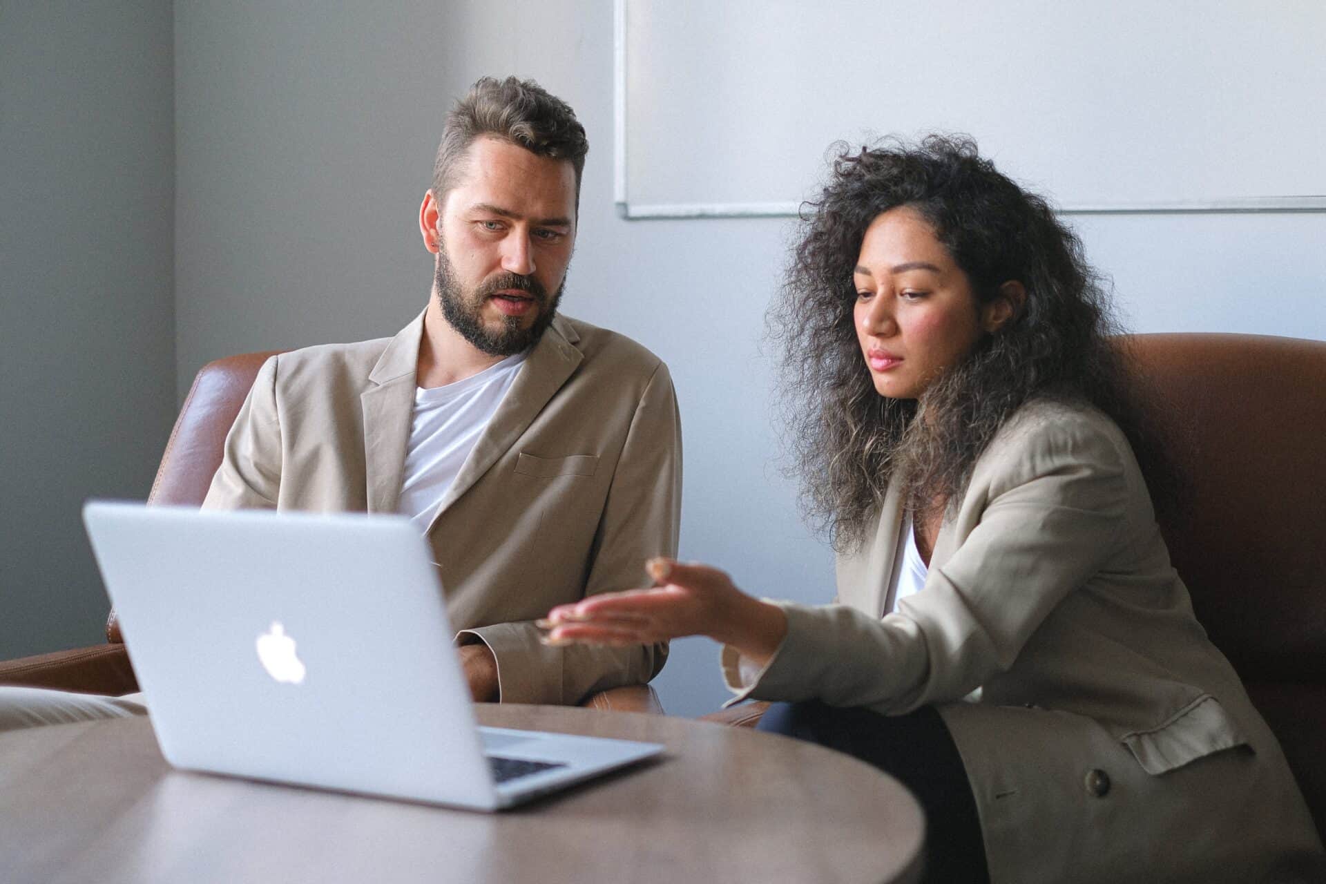 An employee points out the need for managed IT services on their laptop to the business owner.