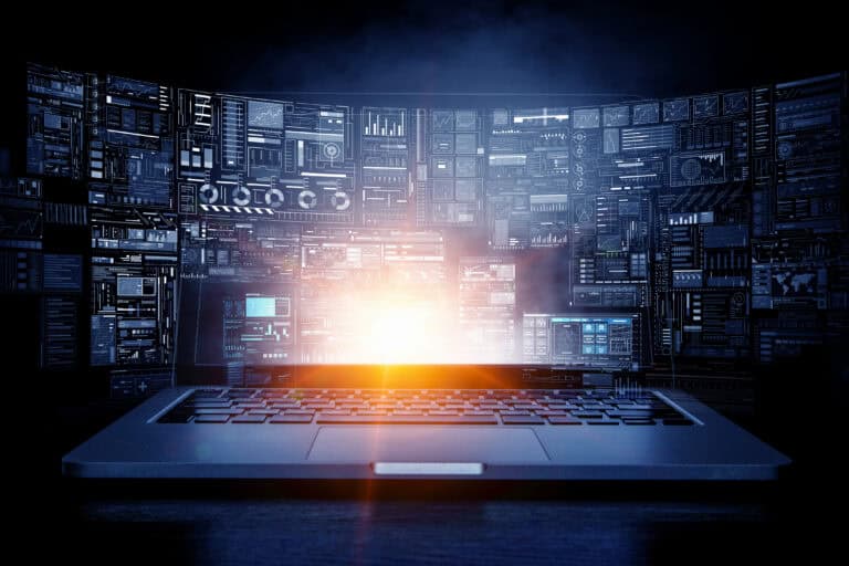 A laptop monitor surrounded by network monitors all around.