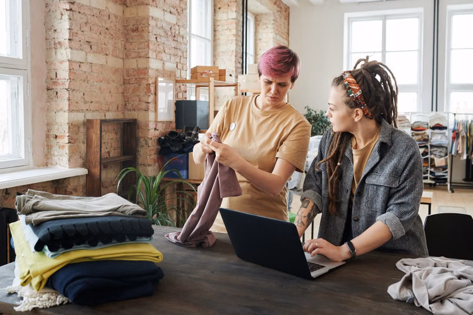 Two women sorting donations with a laptop on the table