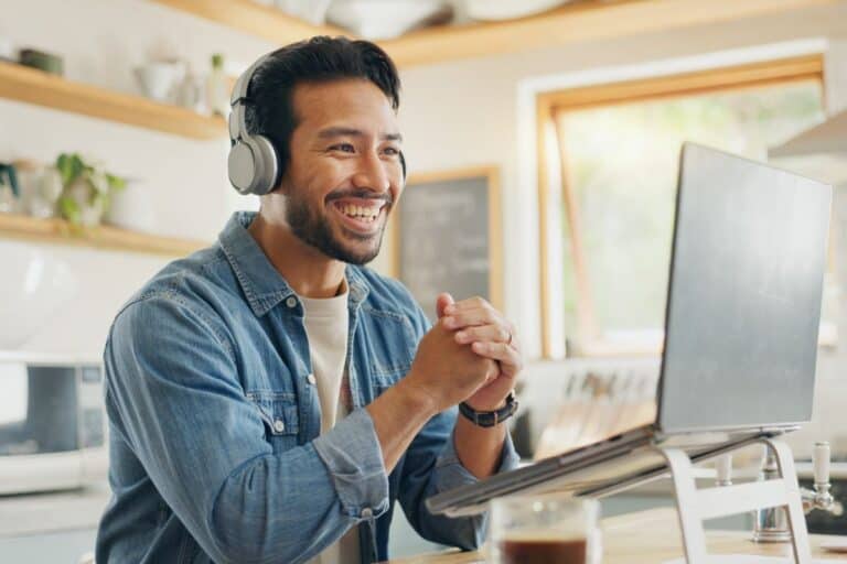 Man working remote from home sitting at laptop on a meeting.