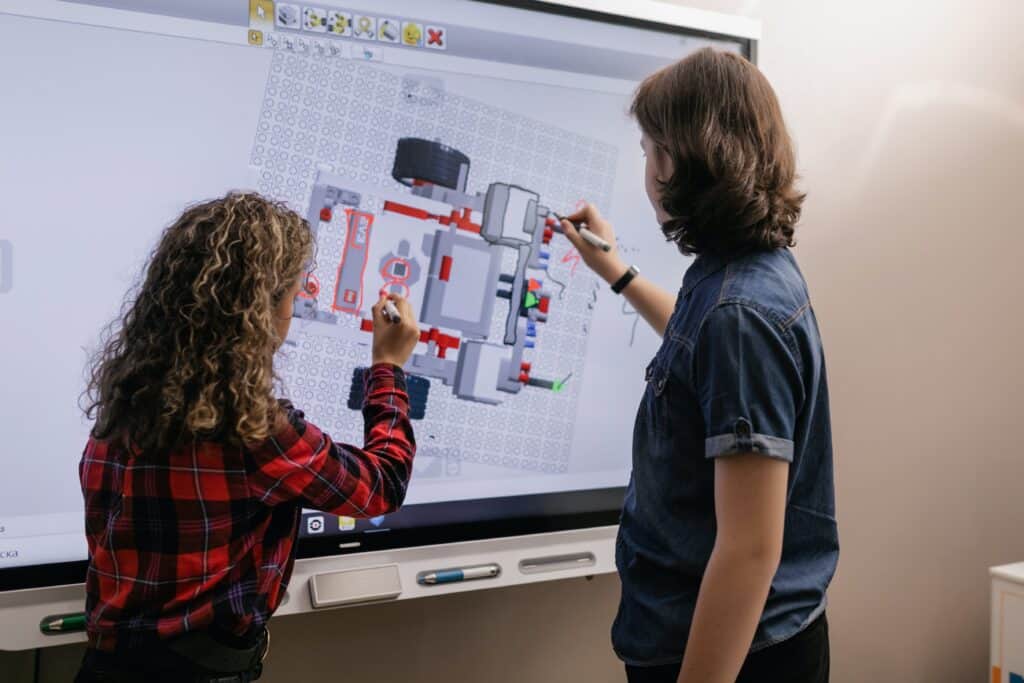 two kids using smart board during class