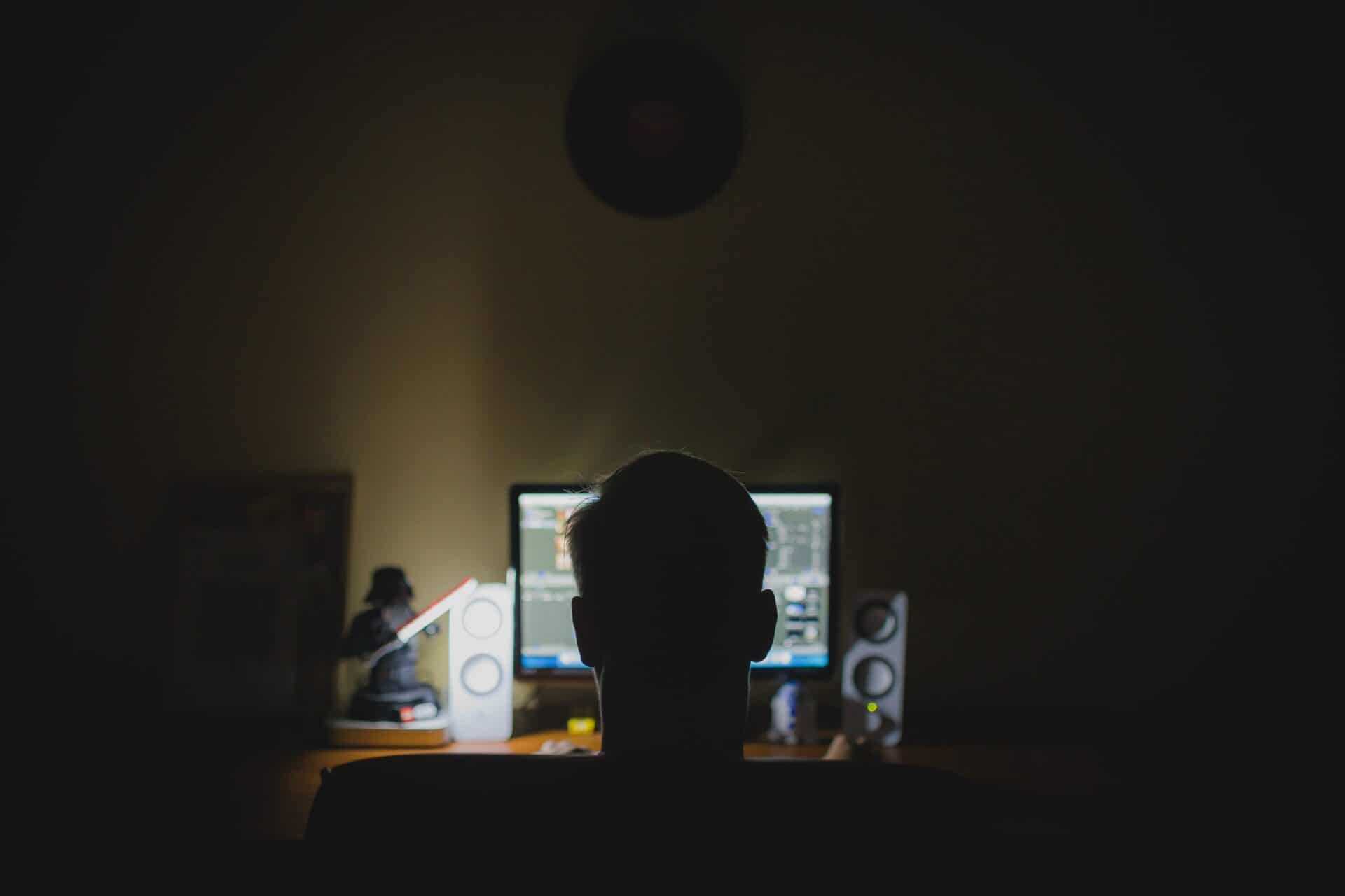 silhouette of man at computer