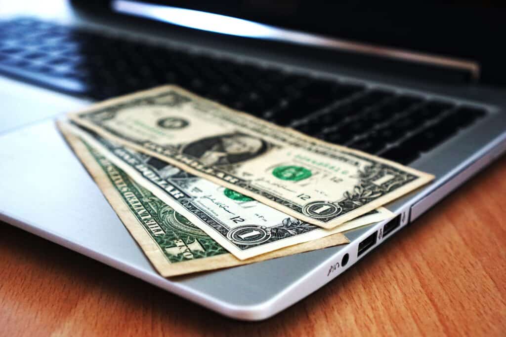 dollar bills on a laptop