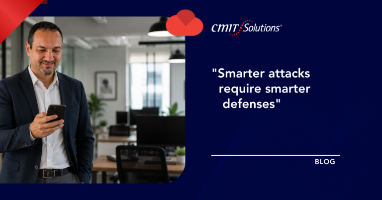 Businessman in a navy suit checks his phone in an office, with the CMIT Solutions blog hero on the right reading 'Smarter attacks require smarter defenses'.
