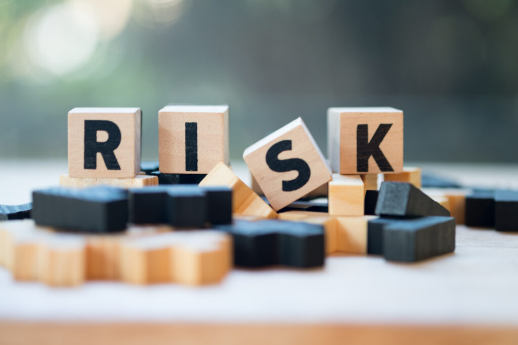 Risk assessment, decision to accept business result in uncertainty, unpredictable situation concept, cube wooden block with alphabet building the word RISK.