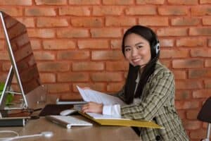 An employee chats with a client through a headset and her computer with call data being encrypted.