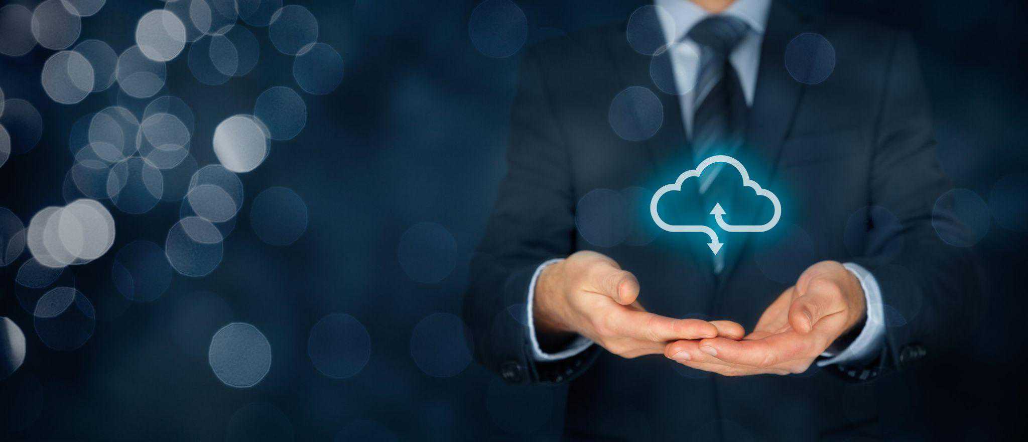 A man in a business suit holds out a glowing cloud download button, depicting cloud migration.