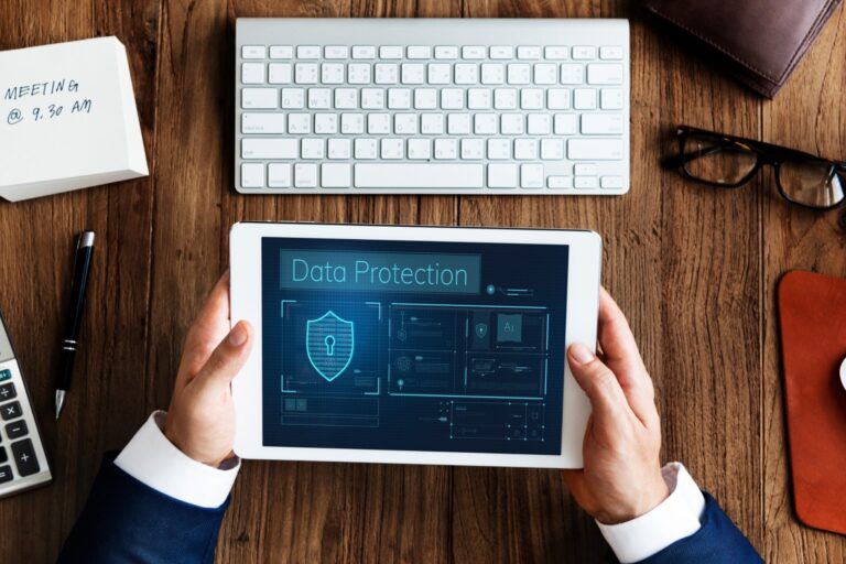 Person using a tablet with digital firewall and data protection icons