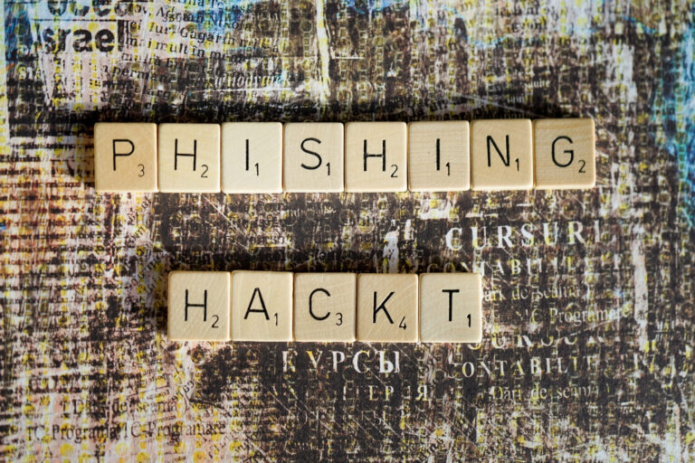 Scrabble tiles spelling phishing and hackt on a textured backgroun