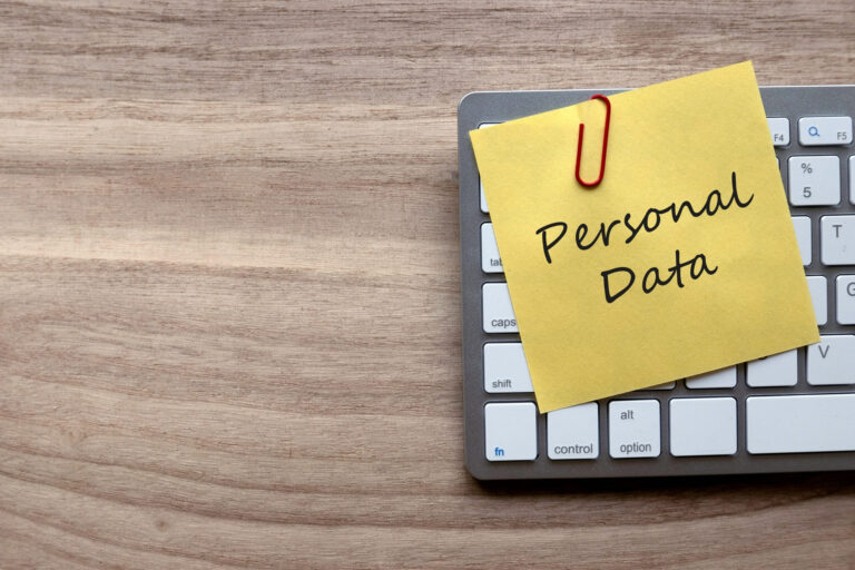 Sticky note with personal data text on computer keyboard