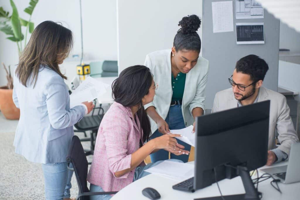 A business owner and employees create an incident response plan together using a computer