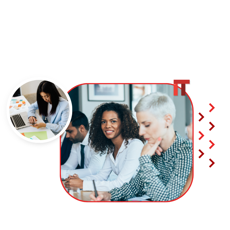 Group of diverse professionals in a meeting; one woman smiles at camera as others work and discuss.