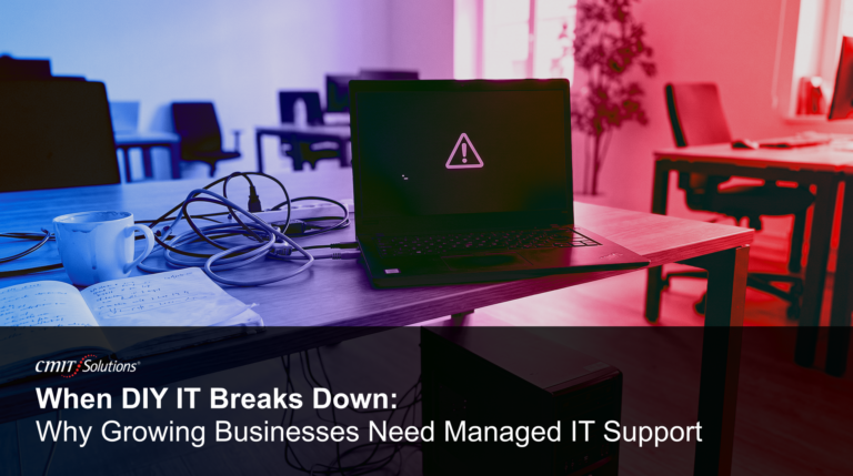 A cluttered office desk with tangled cables and a laptop displaying a warning symbol, illustrating why growing businesses in Des Moines need professional cybersecurity and managed IT support.