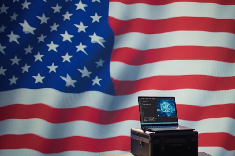 Computer with AI code in front of American flag backdrop