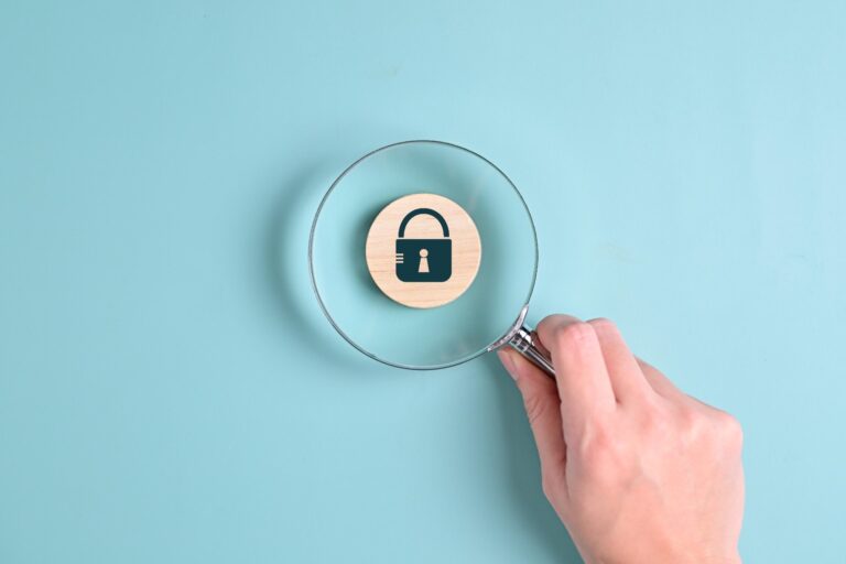 Magnifying glass highlighting padlock icon on blue background