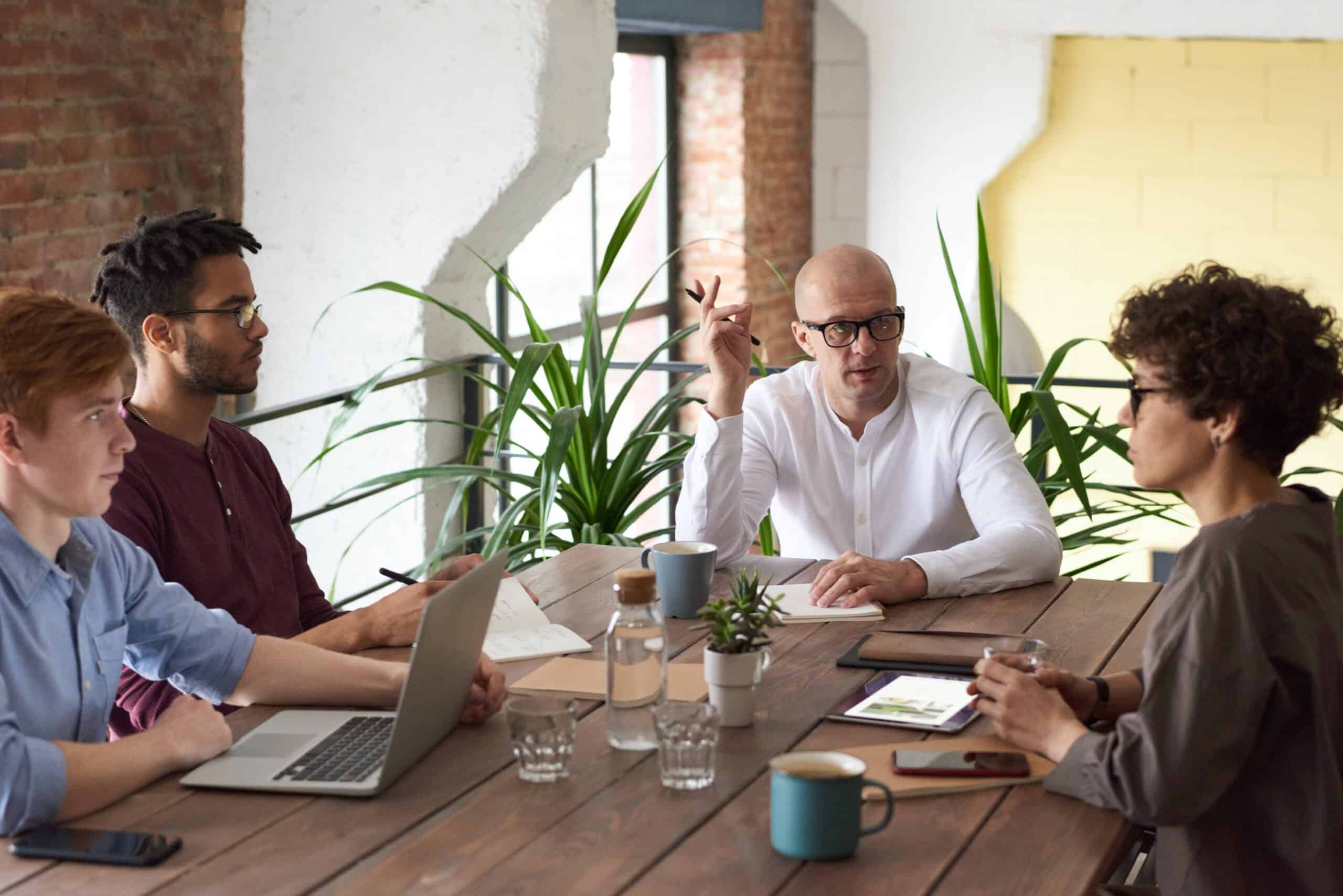 Four coworkers sit around a table discussing data privacy needs during a meeting