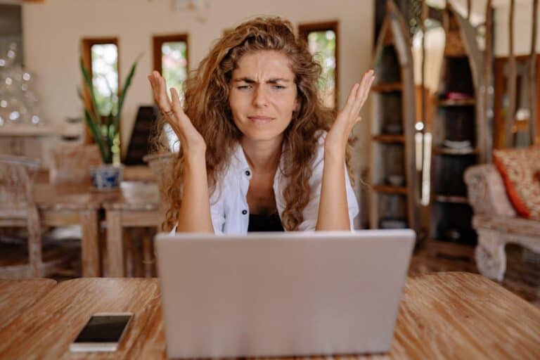 A business owner looks confusedly at her laptop at what is likely a social engineering attack.