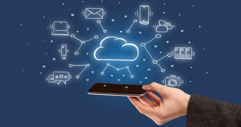 Hand holding cell phone with cloud, cell phone, and other images floating above, representing small business phone systems