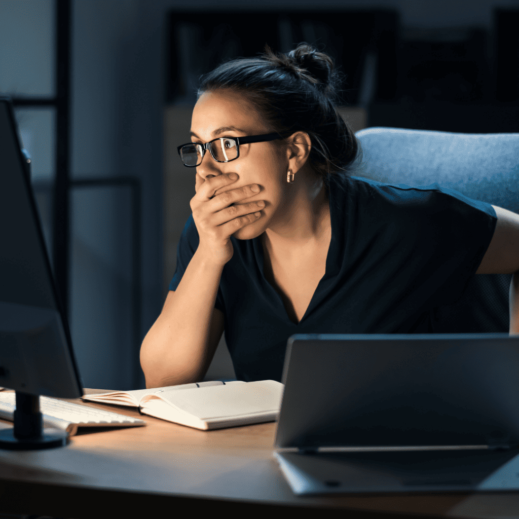 Woman shocked looking at computer screen after data breach