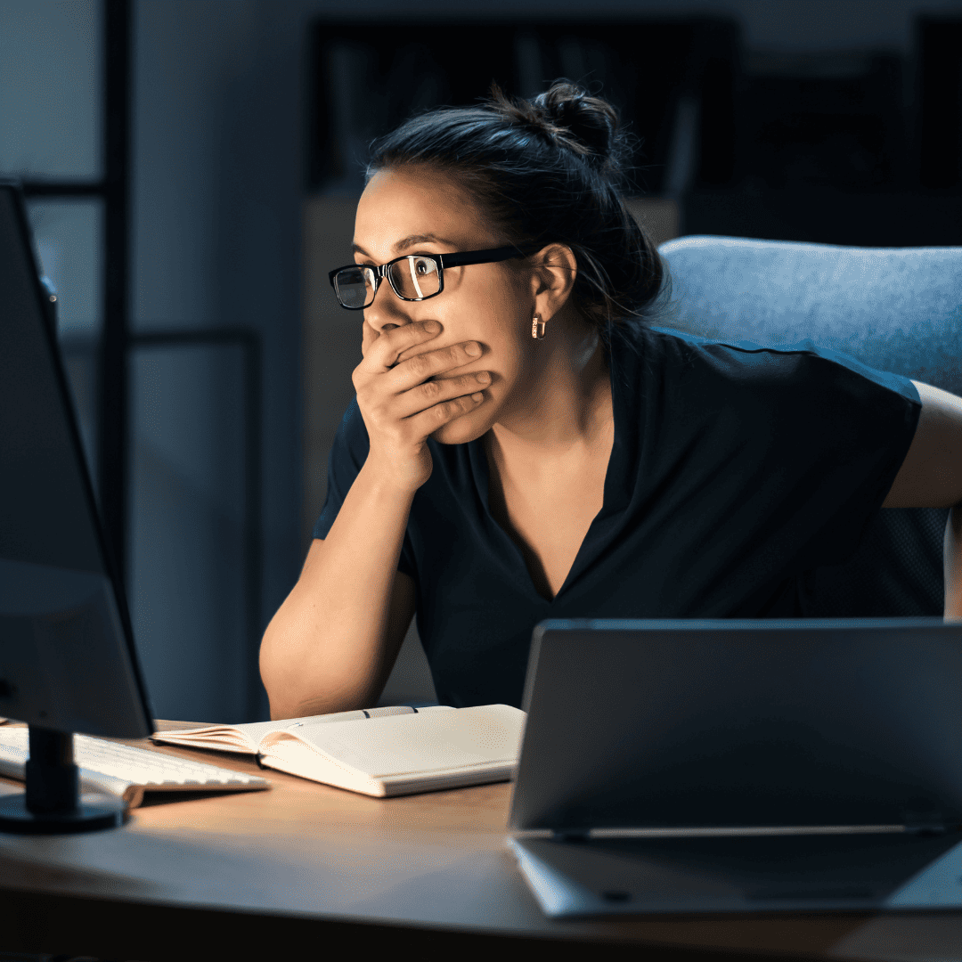 Woman shocked looking at computer screen after data breach
