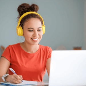 Girl in yellow headphones taking class notes from her laptop
