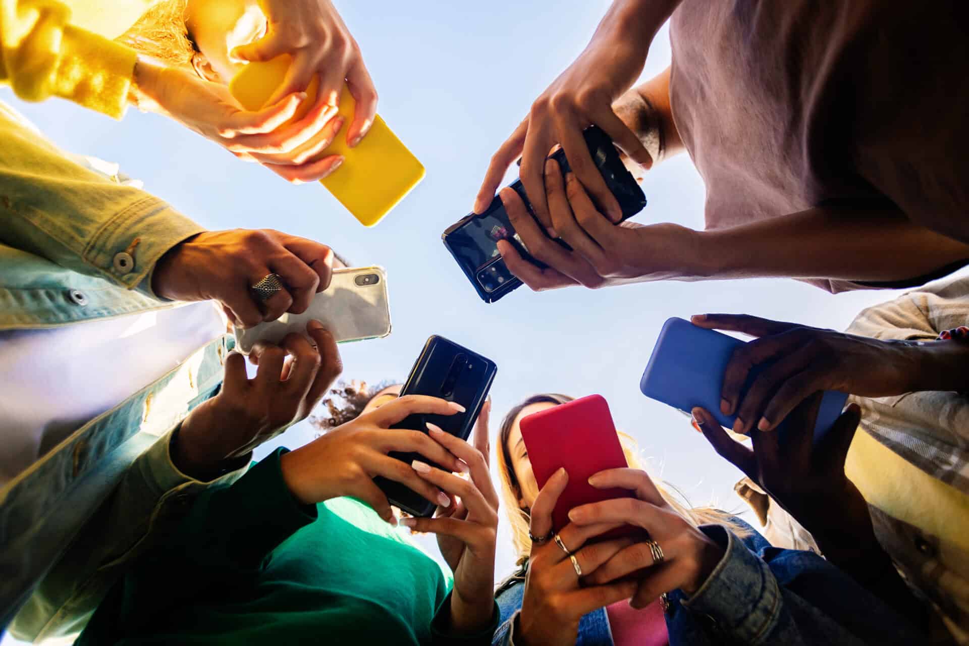 Young group of teenage student people using mobile phone outdoors