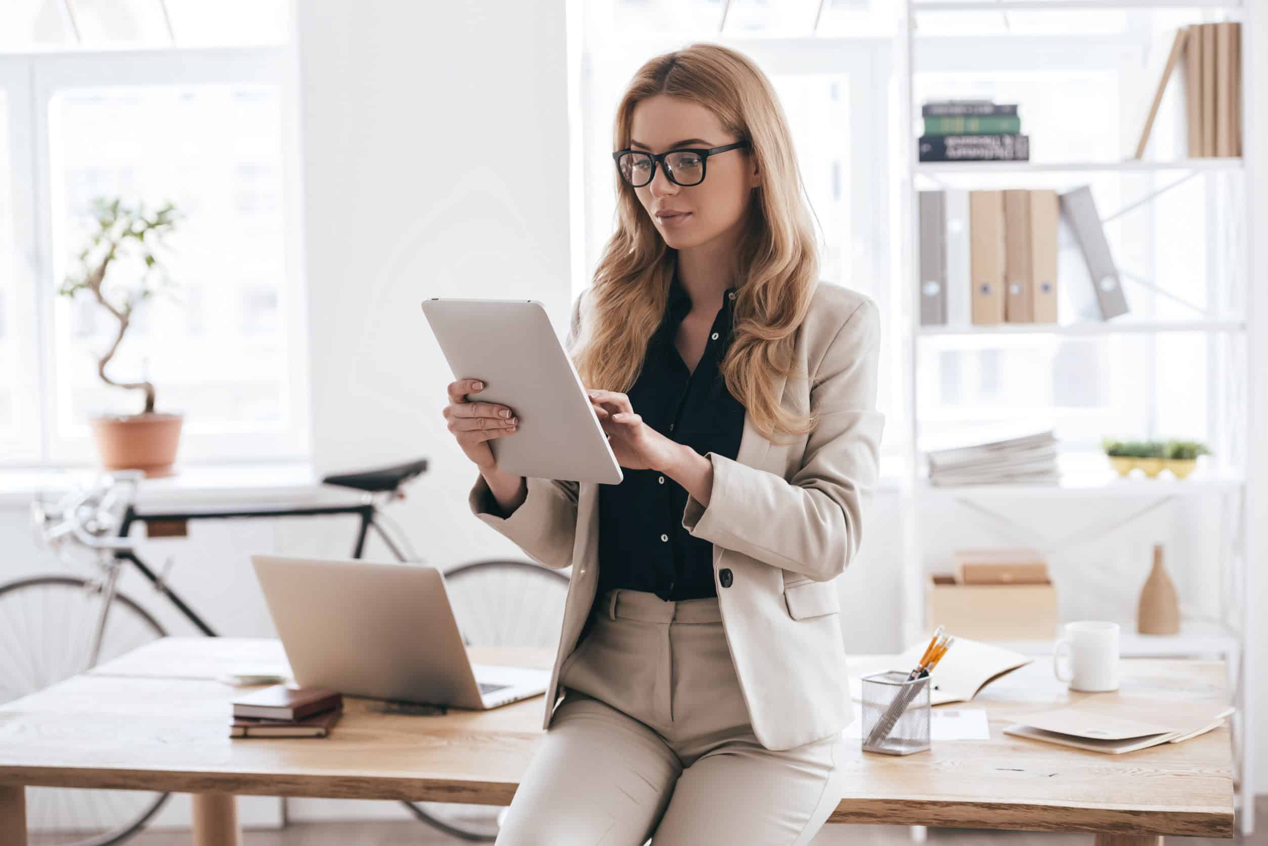 A business owner smiles at her tablet as she sees a message from her managed IT services provider.