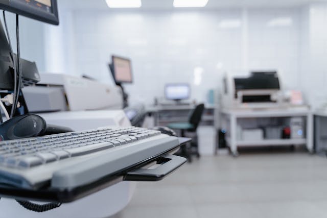 An office workspace with a close-up on a keyboard on a desktop table