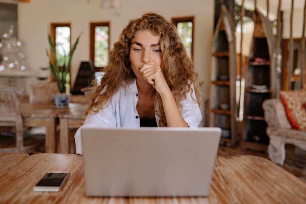 A business owner looks worriedly at her laptop as she upgrades her cybersecurity protocols.