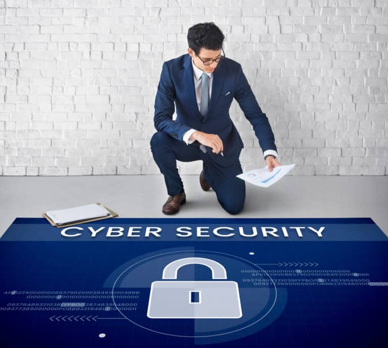 A man in a holding documents and examining a digital display with the words "CYBER SECURITY"