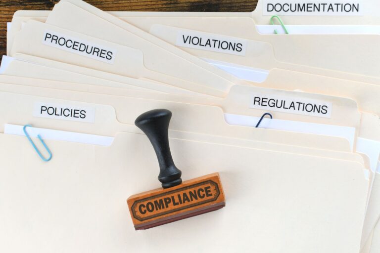 Compliance stamp on folders labeled procedures violations regulations policies and documentation