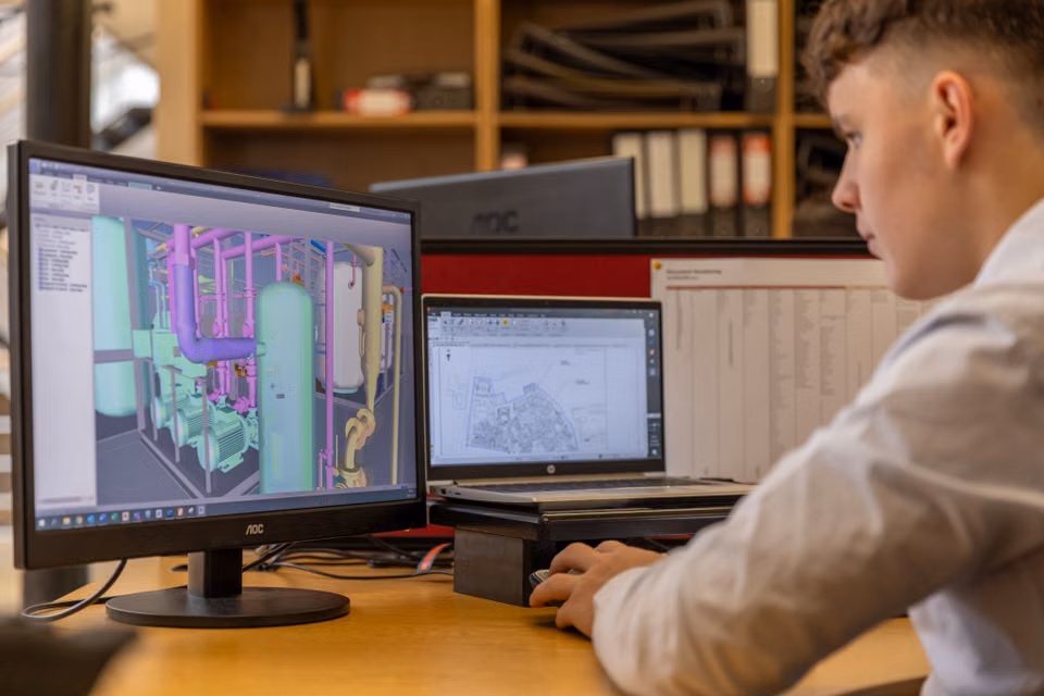 Engineer working with CAD software on dual monitors