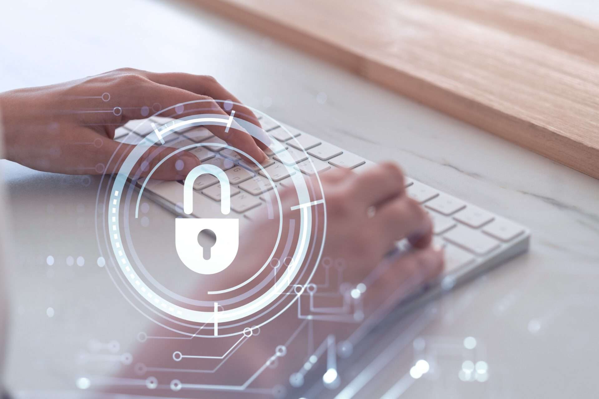 A business owner types on a keyboard with a lock and circuitry above it, symbolizing cybersecurity.