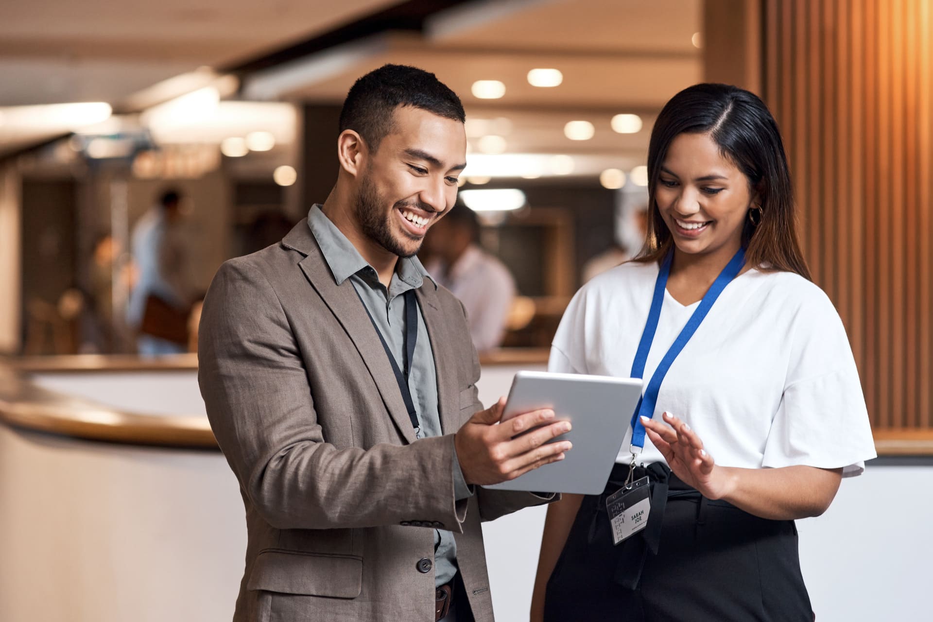 Two business professionals using a digital tablet in a hotel lobby