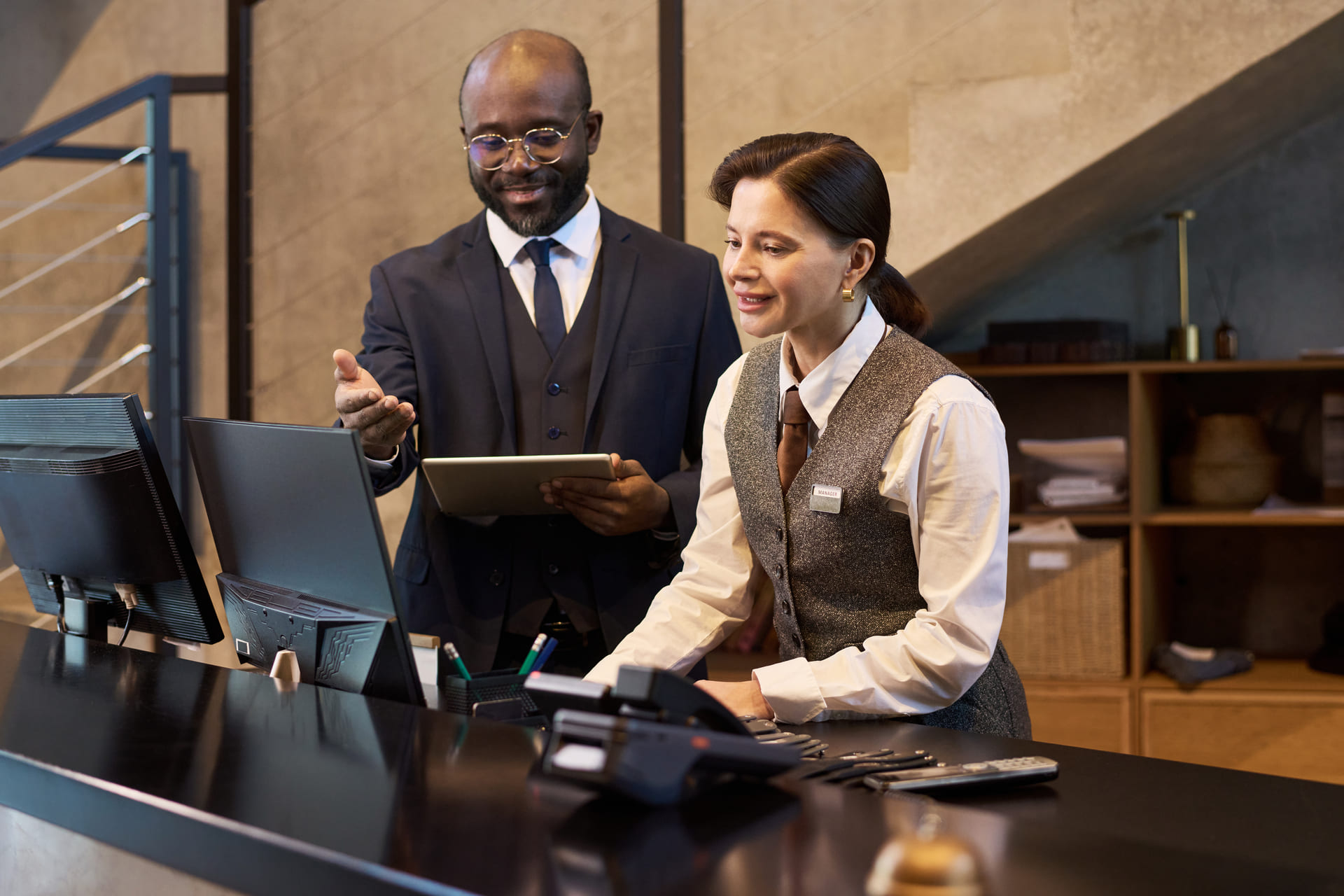 hotel-staff-at-reception-desk-assist-guest