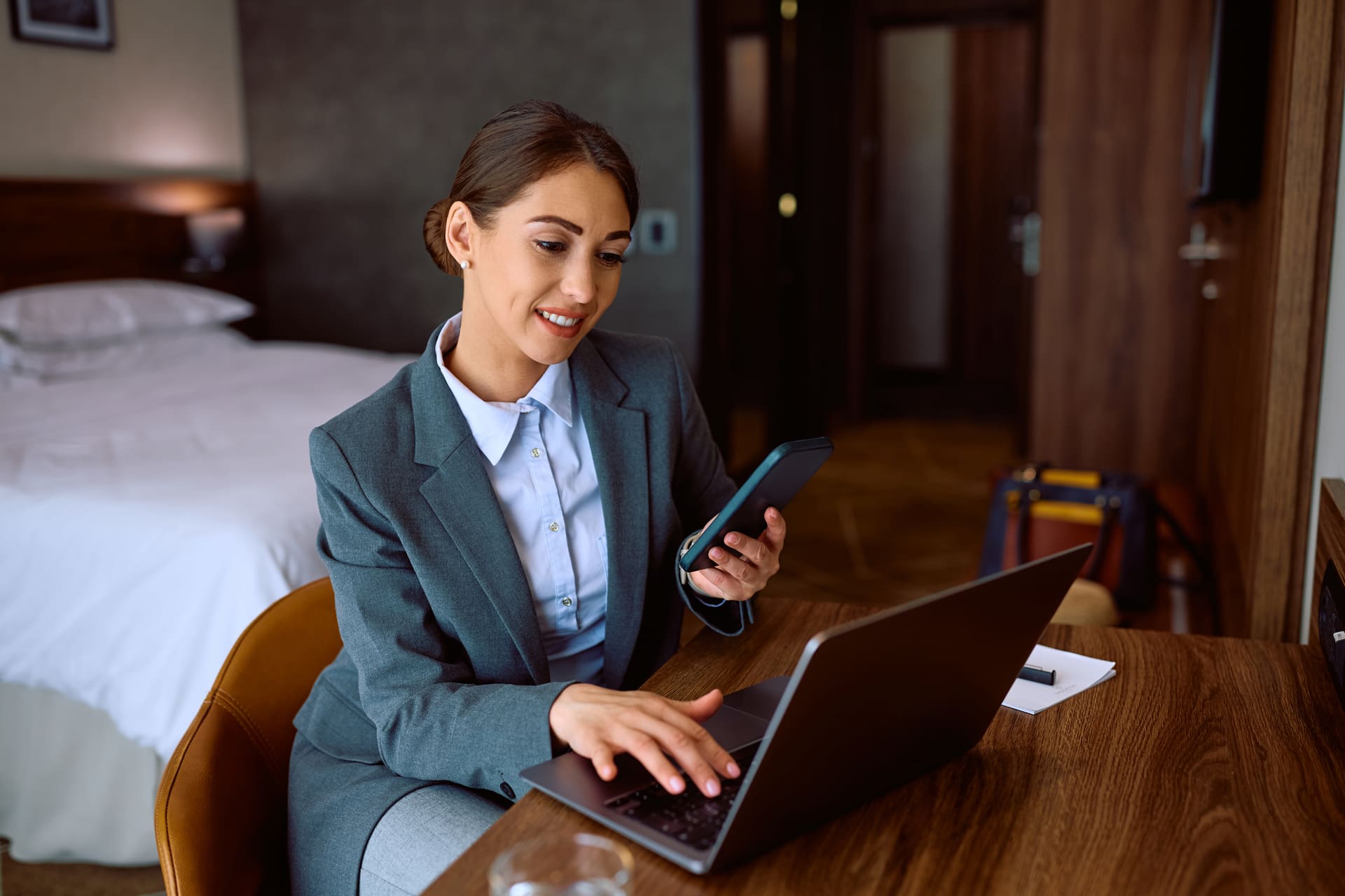 smiling-businesswoman-using-cell-phone-while-working