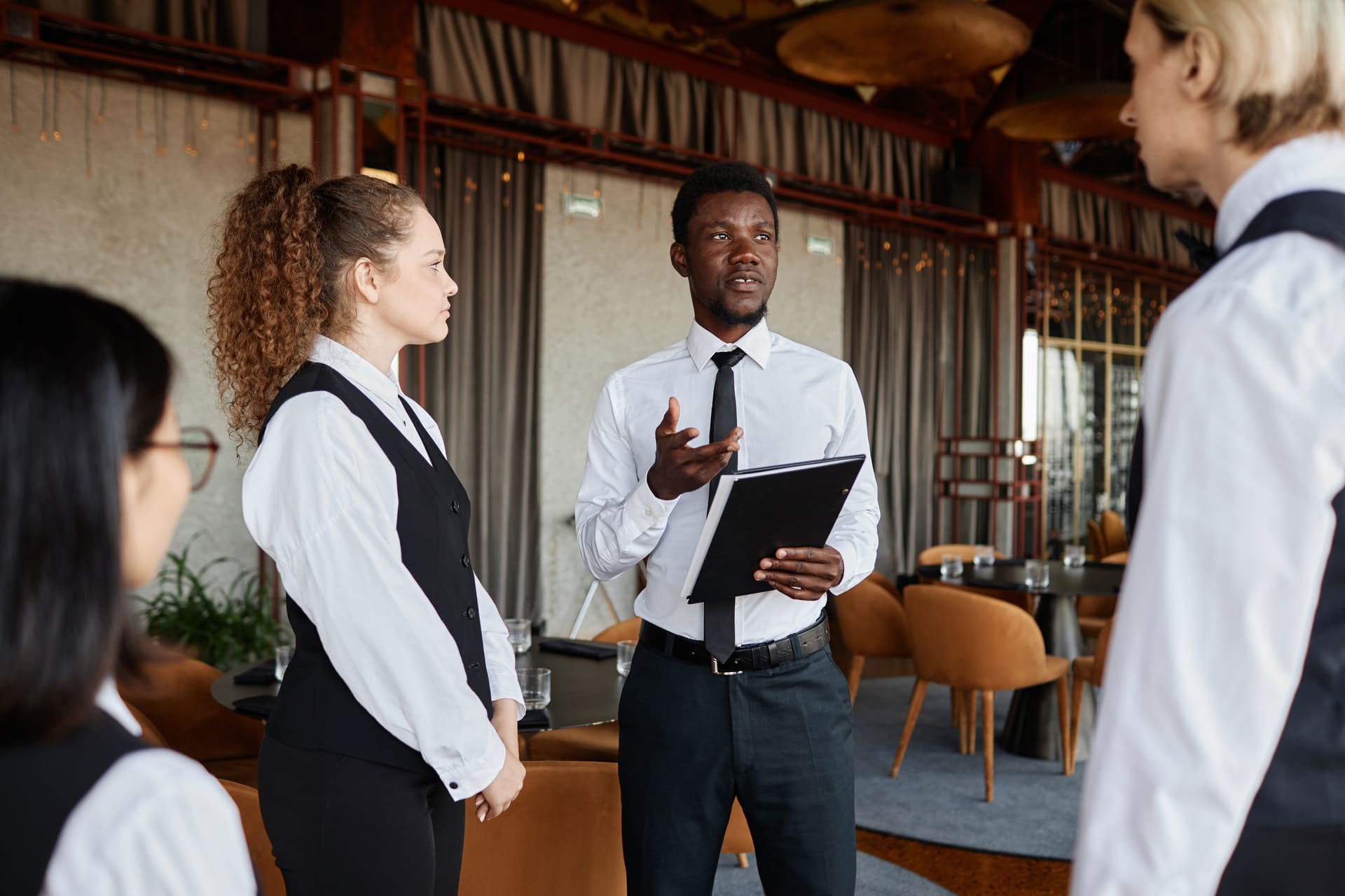 young-man-talking-to-servers-during-staff-meeting