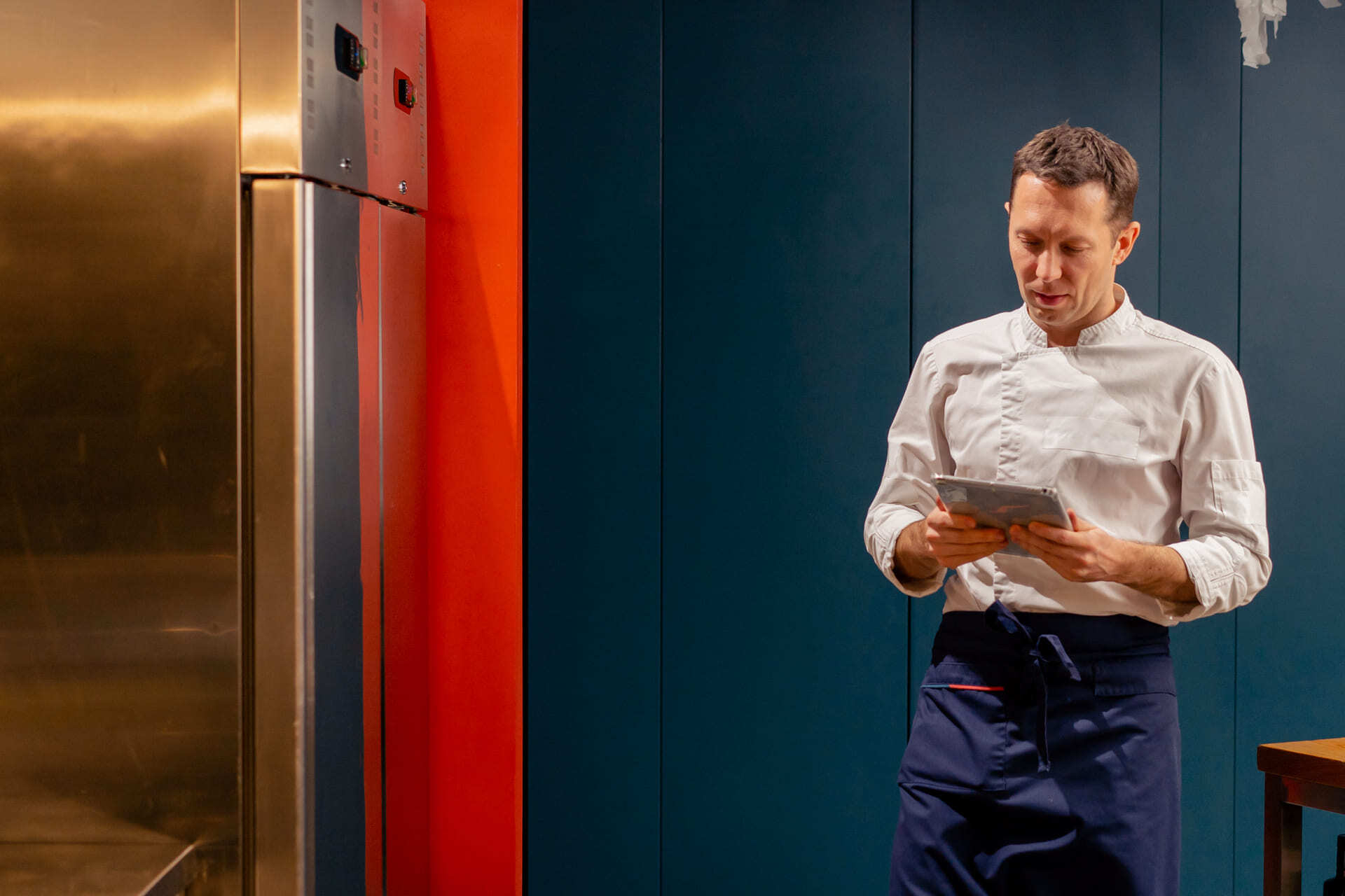 man-in-chef-s-uniform-consults-a-tablet