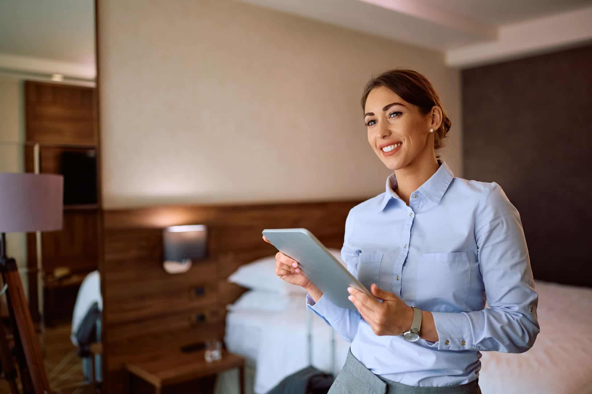 smiling-woman-using-tablet-in-hotel-room